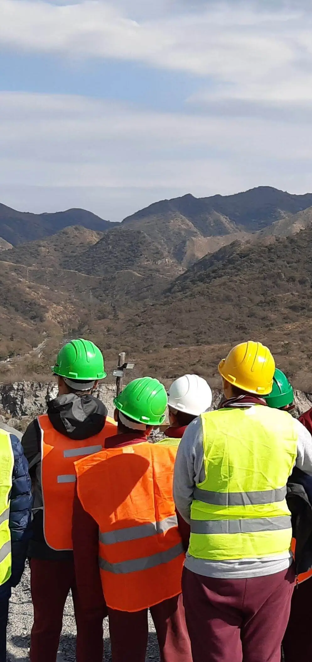 Personas con cascos en un paisaje de sierras